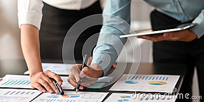 Cropped image of data analyst team working together with computer tablet and graphic charts information. Stock Photo