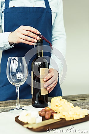 Cropped image of female sommelier opening a bottle of white wine Stock Photo