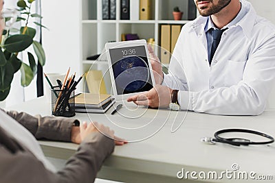 cropped image of general practitioner showing patient ipad Editorial Stock Photo