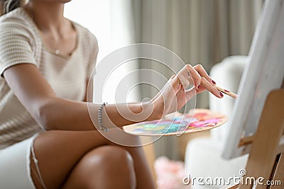 Cropped image, Relaxed woman painting her creative picture on canvas easel Stock Photo