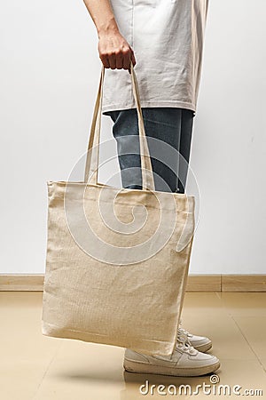 Cropped image of woman holding beige shopping bag in studio Stock Photo