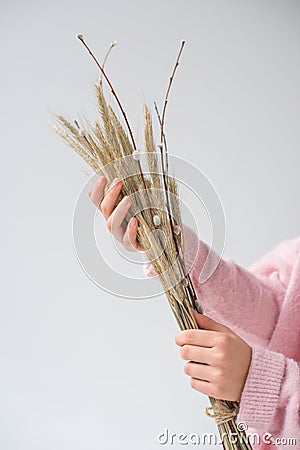 cropped image of woman holding bunch of willow tree branches and spikelets Stock Photo