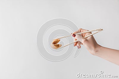 cropped image of woman holding chinese fortune cookie with chopsticks Stock Photo