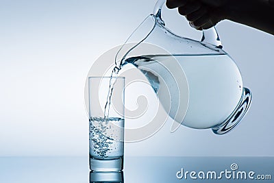 Cropped image of woman pouring water from jug Stock Photo