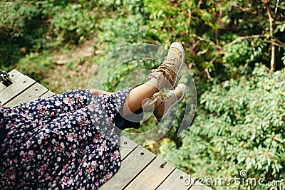 cropped image of woman sitting on wooden footbridge Stock Photo