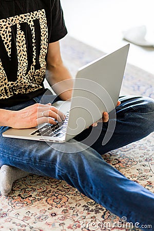 Cropped image of a young man working on computer sitting at wooden table Stock Photo