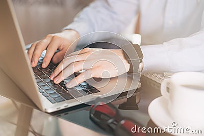 Cropped image of a young man working on his laptop, man hands busy using laptop at office desk, young male student typing on Stock Photo