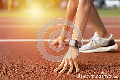 Cropped low angle of female athlete on the starting point of a running track with daylight, preparing for a Stock Photo