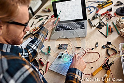 Technician pointing on technical scheme on laptop Stock Photo