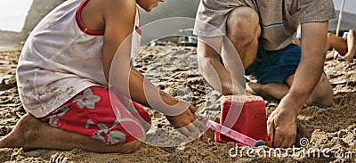 Cropped photo of boy and father building sand castle at beach Stock Photo