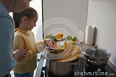 Bonding time in the kitchen for grandma and granddaughter Stock Photo