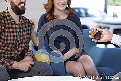 Cropped photo of a couple being handed with car keys in a showroom Stock Photo