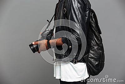 Cropped photo of stylish african man with backpack holding photo Stock Photo