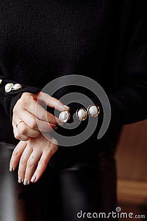 Cropped photo of a stylish woman in black outfit with pearls details. ashion concept Stock Photo