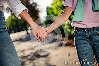 Cropped photo of two lovely friendly girls hold arms morning park nature sunshine free time outside Stock Photo