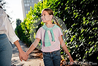 Cropped portrait of two peaceful positive people hold arms walk enjoy pastime chill downtown park outdoors Stock Photo