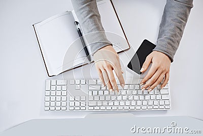 Cropped portrait of woman hands typing on keyboard and working with computer and gadgets. Modern female freelancer Stock Photo