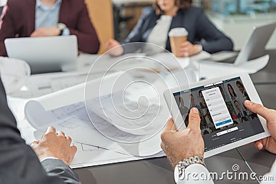 cropped shot of architect using tablet with linkedin website on screen while Editorial Stock Photo