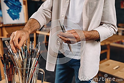 Cropped shot of artist choosing perfect paintbrush Stock Photo