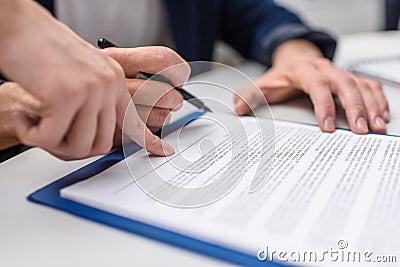 cropped shot of client signing contract while manageress pointing Stock Photo