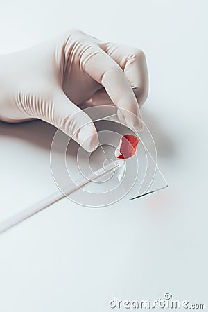 cropped shot of doctor pouring blood from pipette onto blood slide Stock Photo