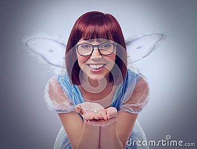 Look, its a first tooth. A cropped shot of a fairy godmother in a blue gown holding a tooth. Stock Photo