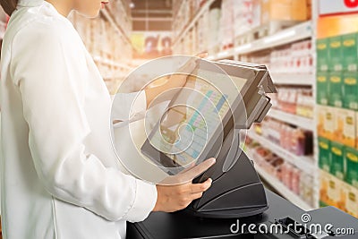 Cropped shot of female cashier staff standing and working with POS or point of sale machine. Stock Photo