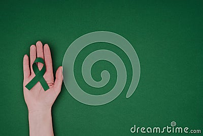 cropped shot of female hand with green awareness ribbon for Green awareness ribbon for Scoliosis, mental health symbol Stock Photo