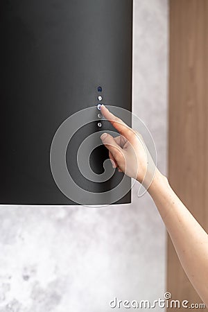 Female hand press button and using black hood extractor Stock Photo