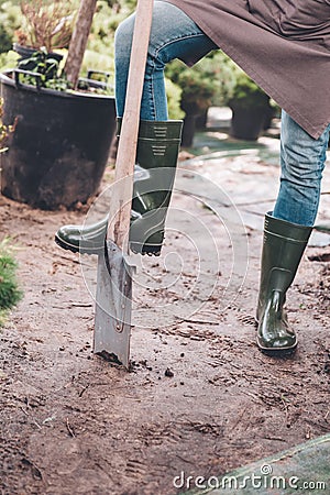 Gardener in rubber boots with spade in garden Stock Photo