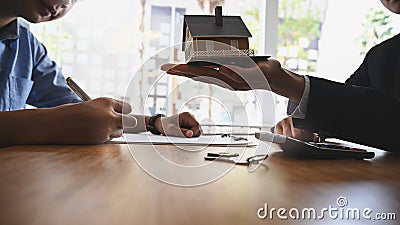 Cropped shot of House broker holding the sample house model in hand with his customer. Stock Photo
