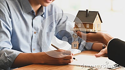 Cropped shot of House broker holding the sample house model in hand with his customer. Stock Photo