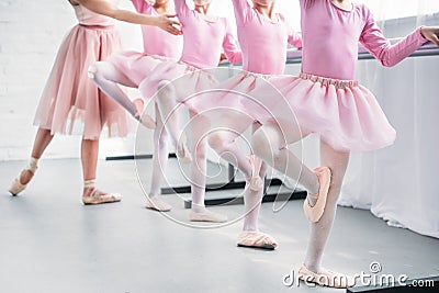 cropped shot of kids in pink tutu skirts practicing ballet with teacher in ballet school Stock Photo