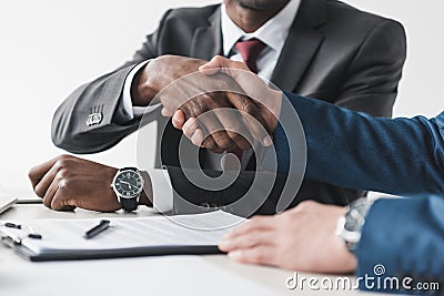 cropped shot of multicultural businessmen shaking hands during contract signing Stock Photo