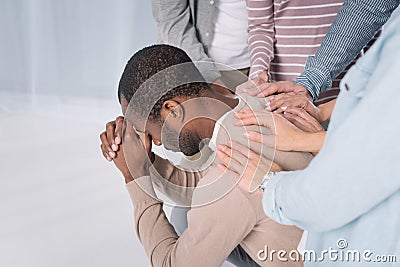 cropped shot of people supporting depressed african american man Stock Photo