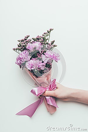Cropped shot of person holding beautiful elegant bouquet of tender purple flowers with ribbon Stock Photo