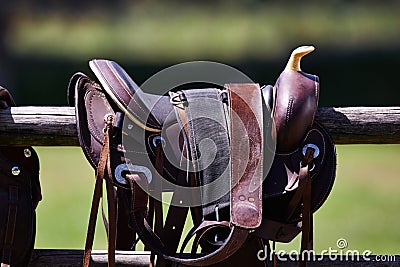 Ready to ride. Cropped shot of a saddle on a fence. Stock Photo