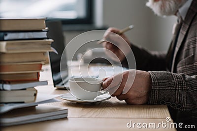 cropped shot of senior writer working with laptop Stock Photo