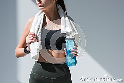 cropped shot of sportswoman with towel holding bottle of water Stock Photo