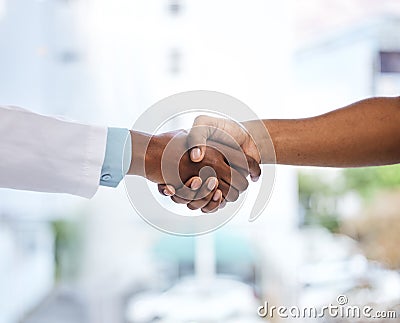 Welcome, please take a seat. Cropped shot of an unrecognizable doctor and patient shaking hands while standing in the Stock Photo