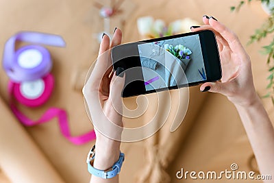 cropped shot of woman holding smartphone and photographing beautiful bouquet of tulips Stock Photo