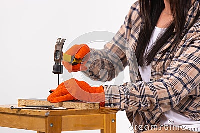 Cropped shot of a woman`s hands hammering a nail on white. Gender stereotypes Stock Photo