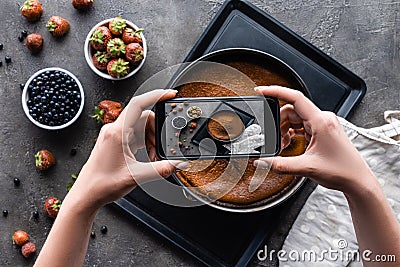cropped shot of woman taking picture of homemade pie on dark Stock Photo