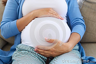 Woman in third trimester touches her belly Stock Photo