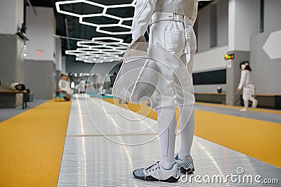 Cropped shot of young fencer wearing protective clothes holding helmet mask Stock Photo