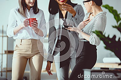 cropped shot of young multiethnic businesswomen drinking coffee and talking Stock Photo