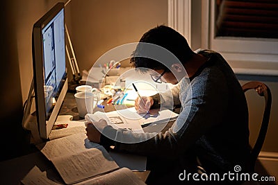 Studying deep into the night. Cropped shot of a young student studying late into the night. Stock Photo