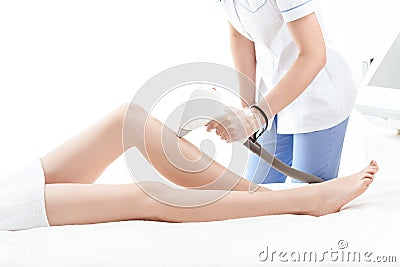 Cropped shot of young woman receiving laser skin care on leg Stock Photo
