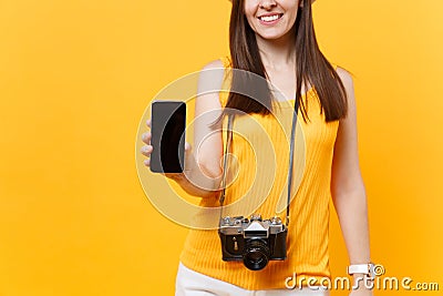 Cropped tourist woman holding mobile smart phone with blank black empty screen isolated on yellow orange background Stock Photo