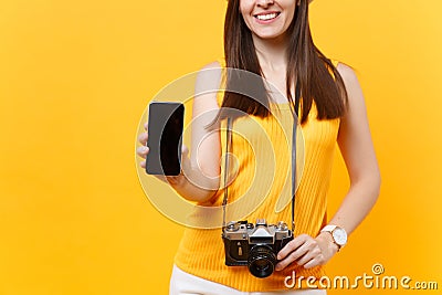 Cropped tourist woman holding mobile smart phone with blank black empty screen isolated on yellow orange background Stock Photo